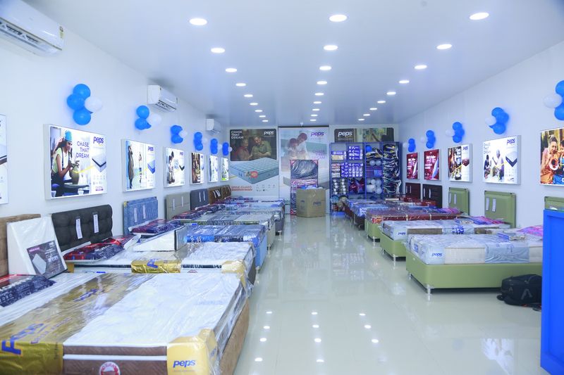 Two rows of Peps mattresses on display beds inside the air-conditioned showroom